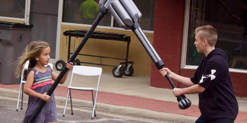 Two kids playing with foam weapons at Art and Stroll