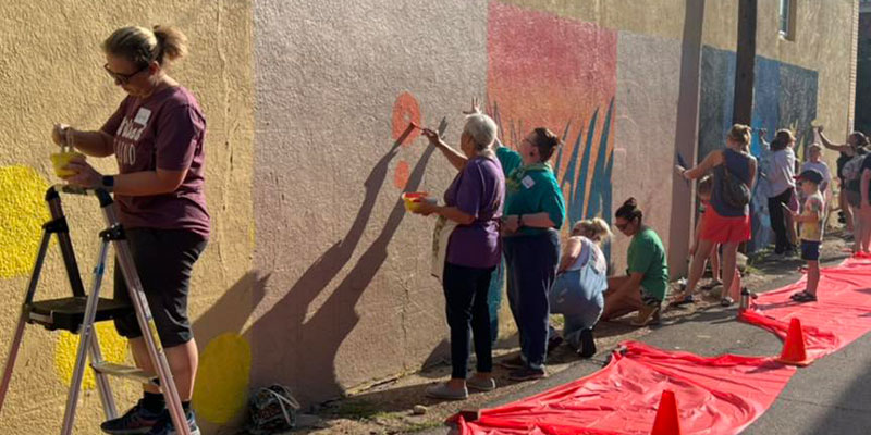 Artists all ages painting in the Alley.