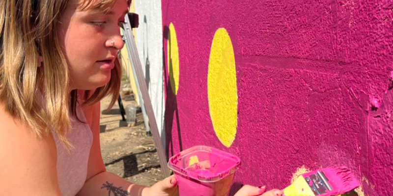 Painter putting the finishing touches on her mural.