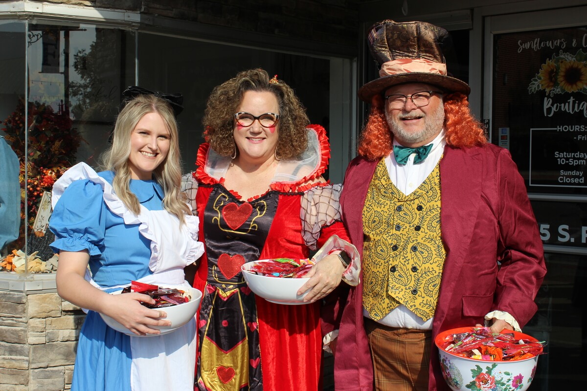 Giving candy out to Trick or Treaters along Downtown
