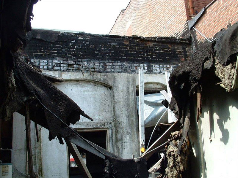 An interior photo of a building showing fire damage and everything destroyed.