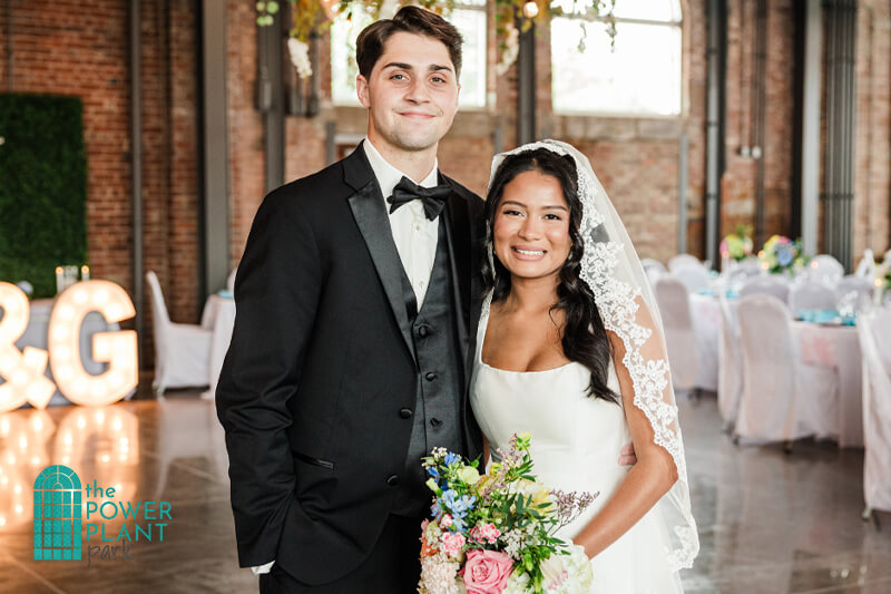 Bride and Groom smiling and posing for a picture at The Station.