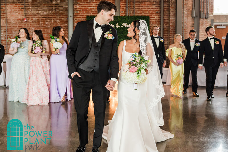 Bride and Groom walking in front of wedding party at The Station.